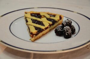 Crostata moelleuse italiana pronta, decorata con frutta fresca e zucchero a velo.