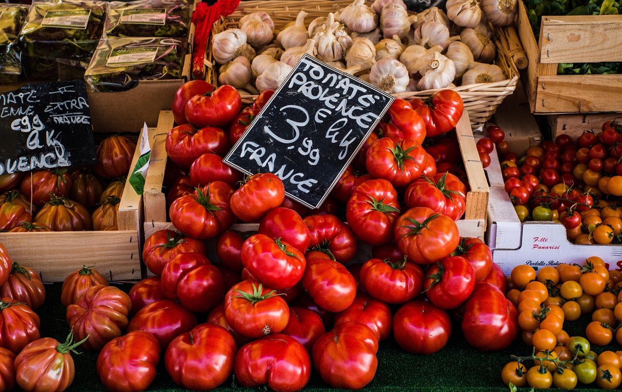 Mercato locale in Francia con bancarelle colorate e prodotti freschi. Atmosfera vivace e visitatori curiosi.